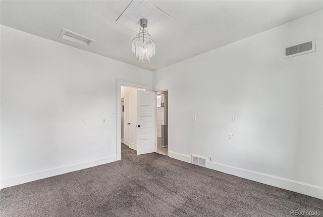 empty room with dark colored carpet, visible vents, and baseboards