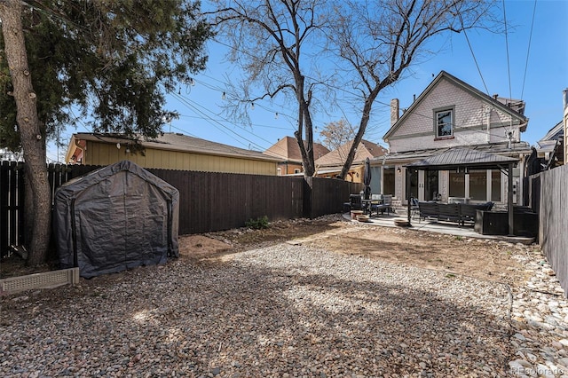 back of property featuring a gazebo, a fenced backyard, a chimney, and a patio area