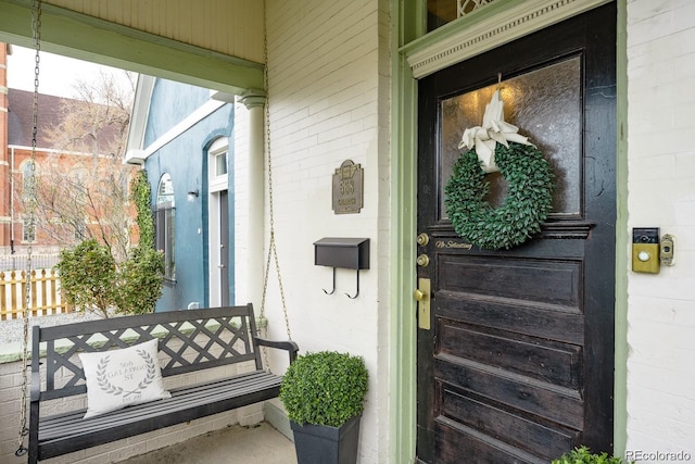 property entrance featuring brick siding and fence