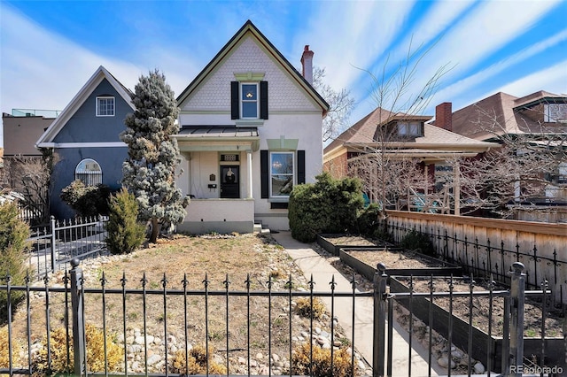 victorian home featuring a standing seam roof, a garden, and a fenced front yard