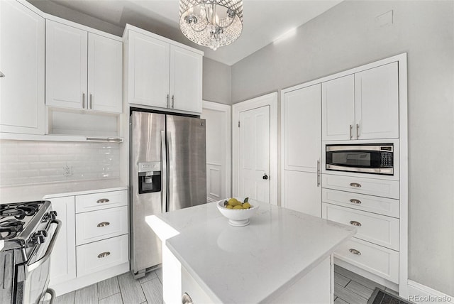 kitchen featuring open shelves, stainless steel appliances, decorative backsplash, white cabinets, and a center island