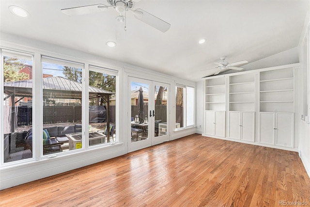 unfurnished sunroom with a ceiling fan and vaulted ceiling