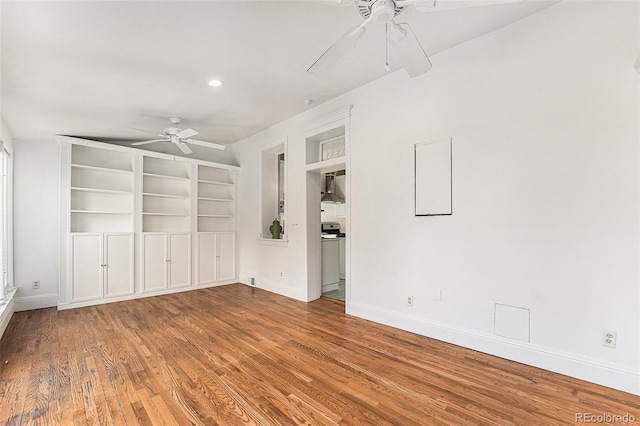 unfurnished room featuring baseboards, ceiling fan, built in features, recessed lighting, and wood finished floors