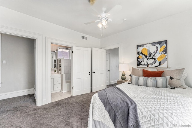 carpeted bedroom featuring visible vents, baseboards, a ceiling fan, and ensuite bathroom