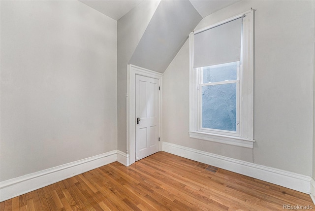 bonus room with vaulted ceiling, visible vents, baseboards, and wood finished floors