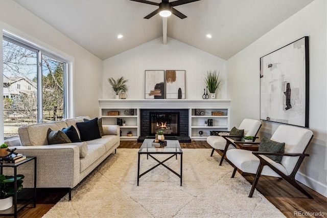 living room with a brick fireplace, lofted ceiling with beams, recessed lighting, wood finished floors, and a ceiling fan