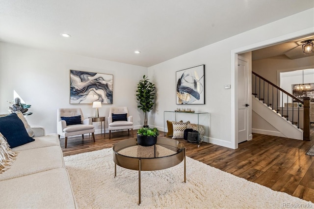 living area featuring a notable chandelier, recessed lighting, stairway, wood-type flooring, and baseboards