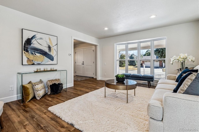 living room with recessed lighting, dark wood-type flooring, and baseboards