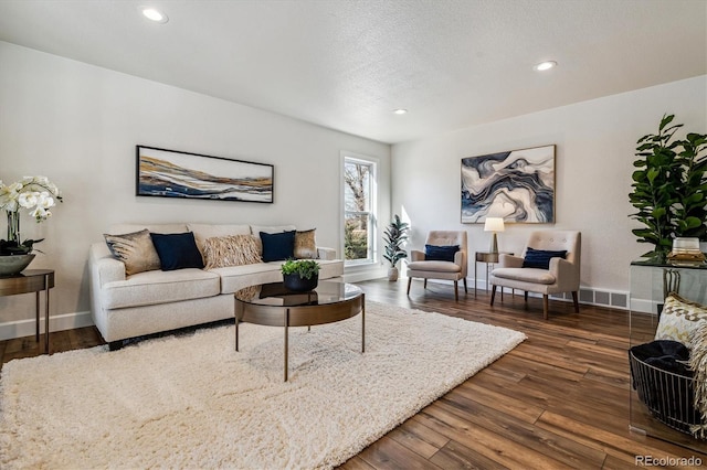 living area with recessed lighting, baseboards, a textured ceiling, and wood finished floors