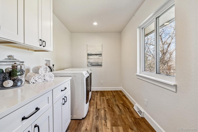 laundry room with visible vents, baseboards, cabinet space, dark wood-style flooring, and washing machine and dryer