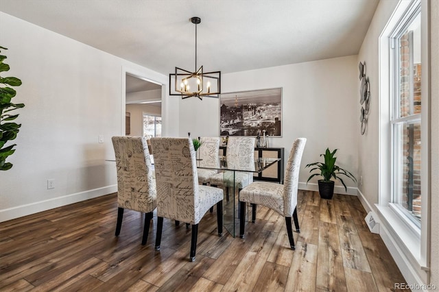 dining room with wood finished floors, baseboards, and a chandelier