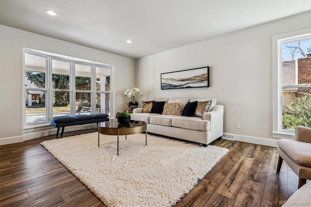 living area with recessed lighting, dark wood-style floors, and baseboards