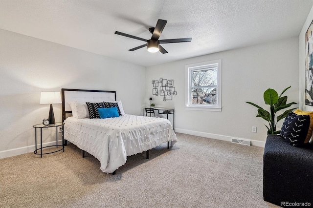 bedroom featuring baseboards, visible vents, carpet floors, and a textured ceiling