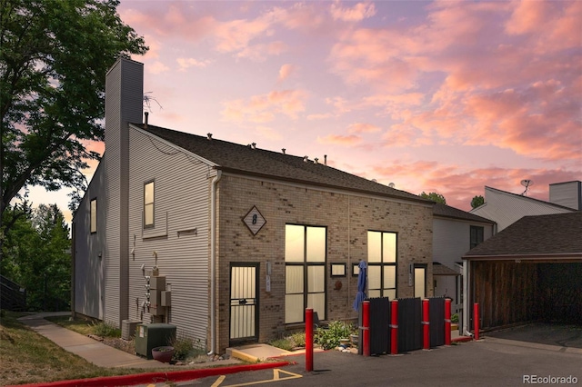 3550 S Harlan St Unit 363, Denver, CO 80235 - back of house featuring brick siding and a chimney