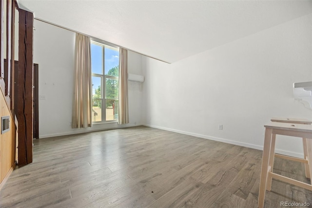 3550 S Harlan St Unit 363, Denver, CO 80235 - unfurnished living room featuring wood finished floors and a wall unit AC