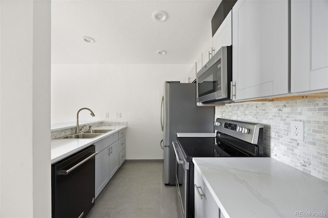 3550 S Harlan St Unit 363, Denver, CO 80235 - kitchen featuring appliances with stainless steel finishes, tasteful backsplash, light stone counters, white cabinets, and recessed lighting