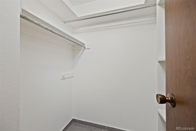 3550 S Harlan St Unit 363, Denver, CO 80235 - laundry room featuring dark tile patterned floors and baseboards