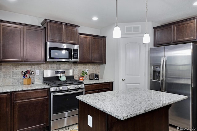 10869 Traders Pkwy, Fountain, CO 80817 - kitchen with appliances with stainless steel finishes, dark brown cabinets, backsplash, light stone countertops, and recessed lighting