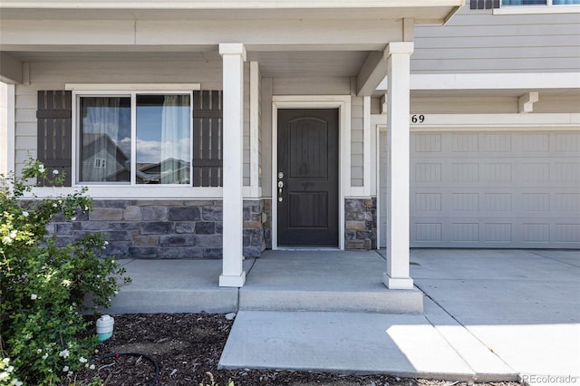 10869 Traders Pkwy, Fountain, CO 80817 - view of exterior entry with a porch, an attached garage, stone siding, and driveway
