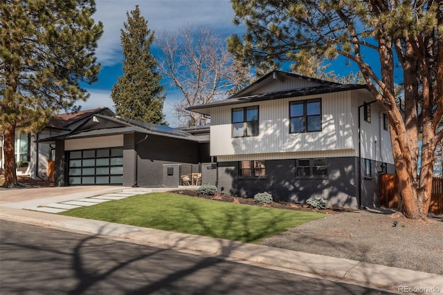 tri-level home featuring concrete driveway, brick siding, a front lawn, and an attached garage