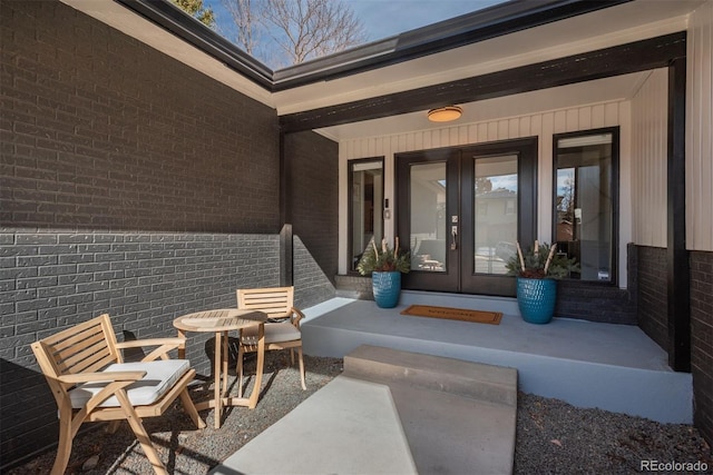 view of exterior entry with french doors and brick siding