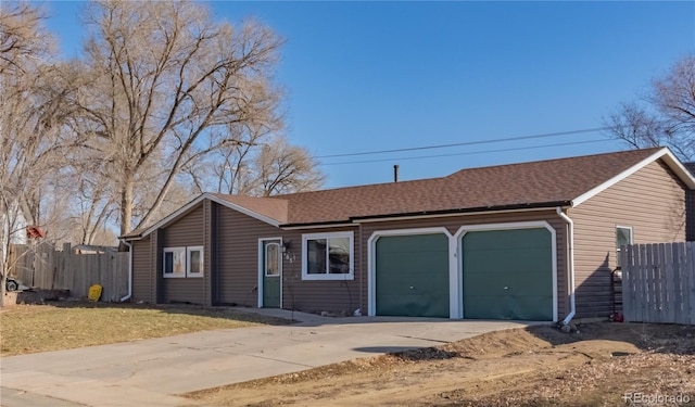 single story home featuring an attached garage, fence, concrete driveway, and roof with shingles