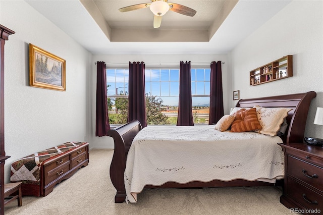 14805 Quince Way, Thornton, CO 80602 - bedroom featuring a tray ceiling, light carpet, multiple windows, and a ceiling fan