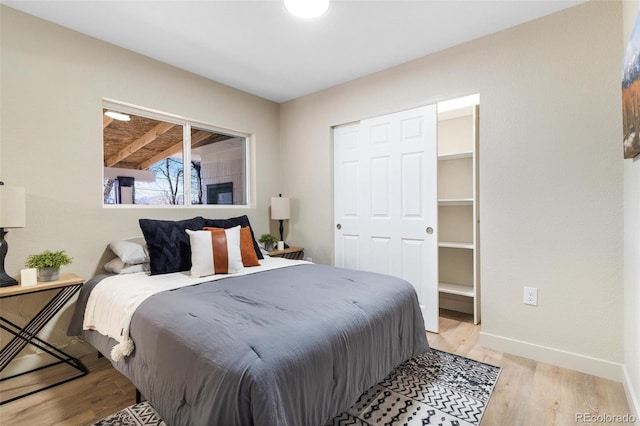 bedroom with light hardwood / wood-style floors and a closet