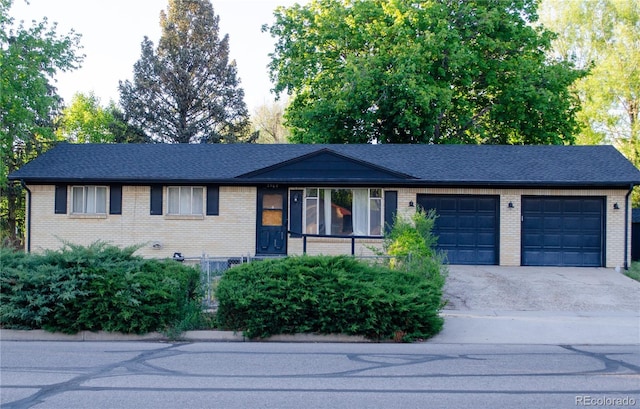2308 Lelaray St, Colorado Springs, CO 80909 - ranch-style home with an attached garage, driveway, brick siding, and a shingled roof