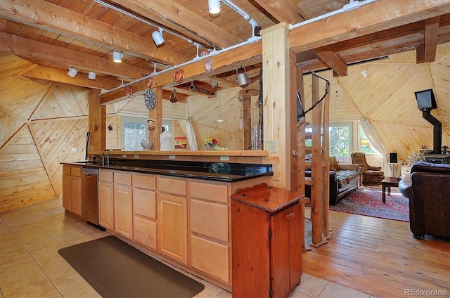 kitchen featuring dishwasher, light hardwood / wood-style floors, light brown cabinets, wooden walls, and vaulted ceiling with beams