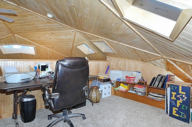 carpeted office space featuring wood walls, lofted ceiling with skylight, and wooden ceiling