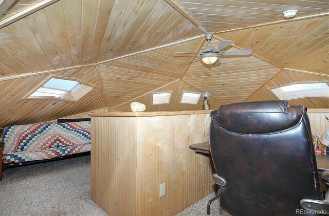 additional living space with wood walls, vaulted ceiling with skylight, ceiling fan, and wooden ceiling