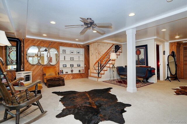 interior space with wood walls, ceiling fan, light carpet, and ornamental molding