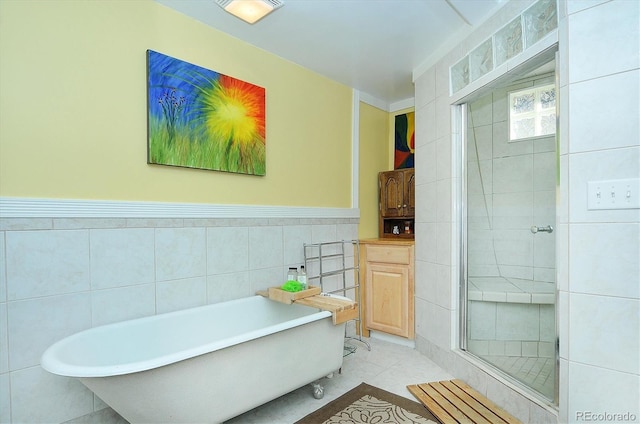 bathroom with tile walls, separate shower and tub, and tile patterned floors