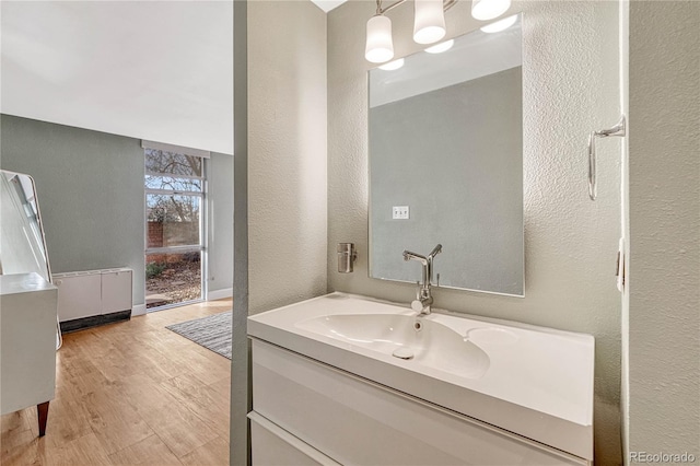 bathroom featuring wood-type flooring, vanity, and radiator heating unit