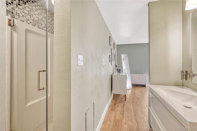 bathroom featuring hardwood / wood-style flooring, vanity, and radiator heating unit