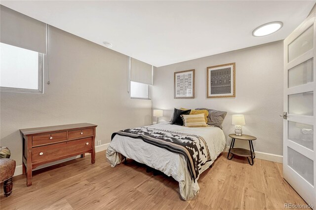 bedroom with multiple windows and light wood-type flooring