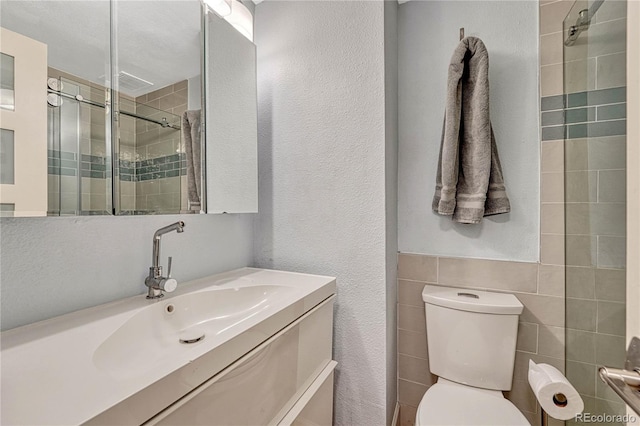 bathroom with vanity, a shower with shower door, and toilet