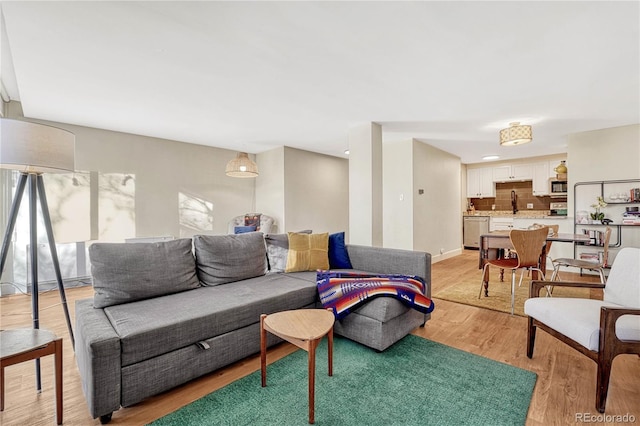 living room featuring sink and light hardwood / wood-style flooring