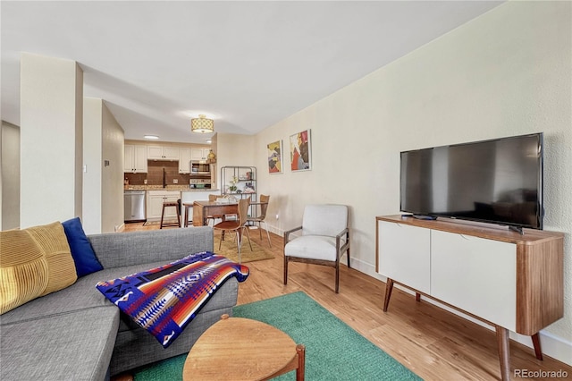 living room with sink and light wood-type flooring