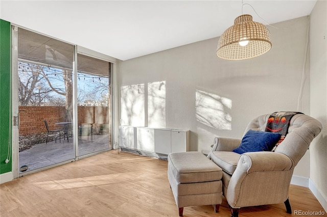 sitting room with wood-type flooring and expansive windows