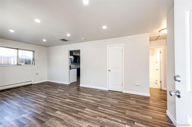 spare room with a baseboard radiator and dark hardwood / wood-style floors