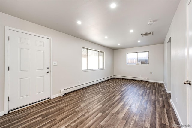 empty room featuring a baseboard heating unit and dark hardwood / wood-style floors