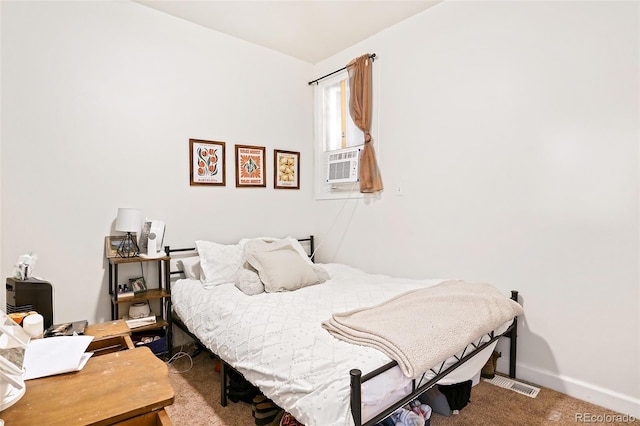 carpeted bedroom with cooling unit, visible vents, and baseboards