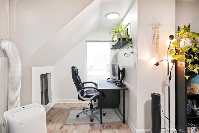 office space with baseboards, lofted ceiling, and wood finished floors