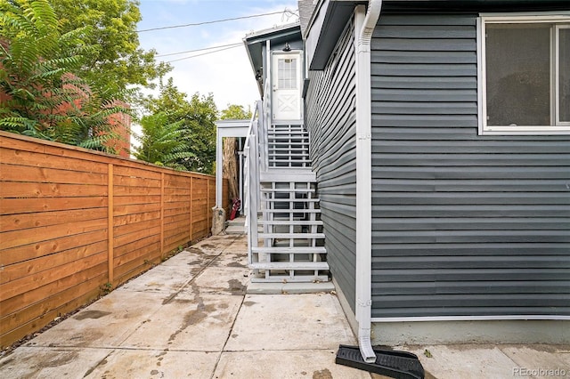 view of home's exterior with a patio and fence