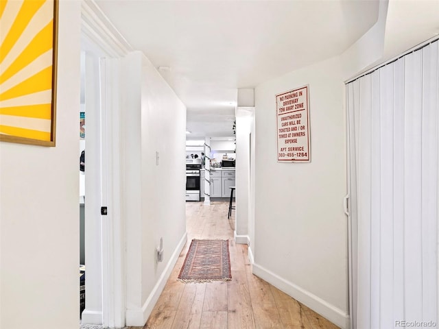 corridor featuring baseboards and light wood-style floors