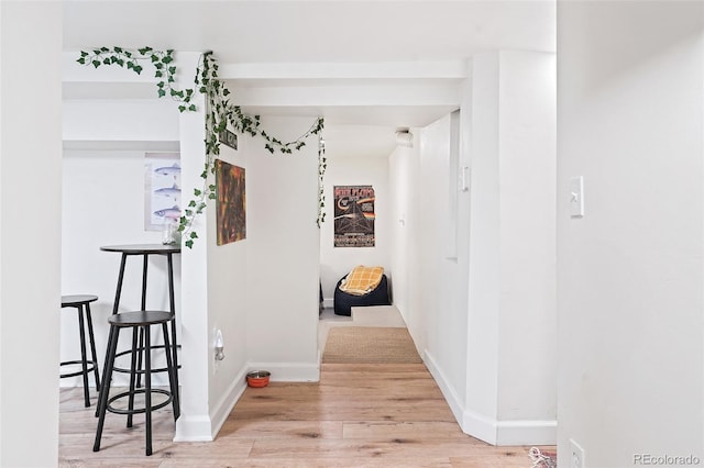 corridor with wood finished floors and baseboards