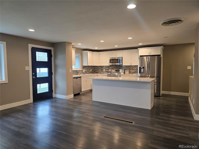 795 Vivian Ct, Lakewood, CO 80401 - kitchen with stainless steel appliances, baseboards, tasteful backsplash, light countertops, and dark wood-type flooring
