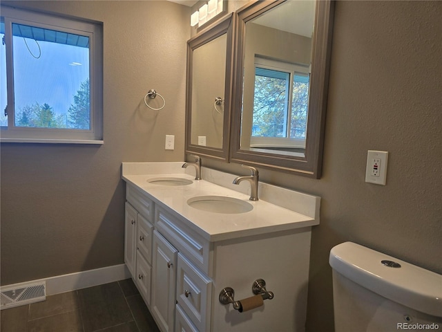 795 Vivian Ct, Lakewood, CO 80401 - full bath with double vanity, tile patterned flooring, baseboards, toilet, and a textured wall